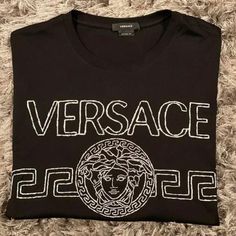 Mens Versace Shirt In A Size Medium Comes New With Tags Designer Cotton Shirt With Logo Print, Black Cotton Tops With Designer Logo, Luxury Black Shirt With Graphic Print, Designer Black Shirt With Logo Print, Black Luxury Top With Monogram Print, Designer Crew Neck Shirt With Logo Print, Luxury Black Top With Logo Print, Designer Black Crew Neck Shirt, Designer Black Monogram Print Top