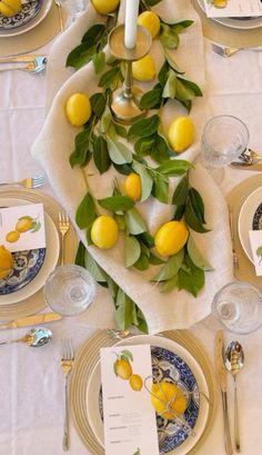 the table is set with lemons and place settings for two people to sit at