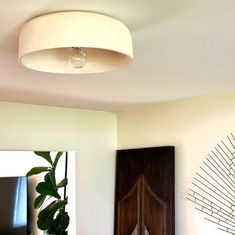 a living room with white walls and wood accents on the wall, including a round light fixture