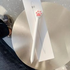 a white toothbrush sitting on top of a silver table next to a person's feet