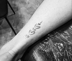 a woman's arm with two hearts and an arrow tattoo on the left forearm