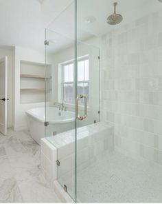 a white bathroom with a glass shower door