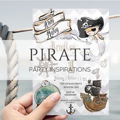 a person holding up a pirate party card next to a rope with an anchor and ship on it