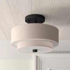 a light fixture hanging from the ceiling in a room with white walls and wood paneling