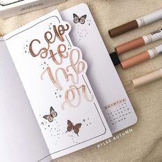 an open notebook with writing on it next to markers and pencils