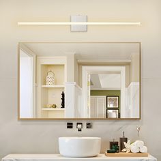 a bathroom sink sitting under a mirror next to a white counter top with a bowl on it