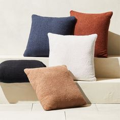 four different colored pillows sitting on top of each other