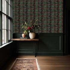 a vase with flowers is sitting on a table in front of a wallpapered room