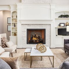 a living room with two couches and a fire place in it's center