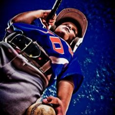 a man holding a baseball bat in his right hand and wearing a catchers mitt