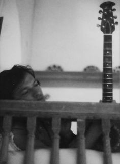 a woman laying in her crib with a guitar on the wall behind her,