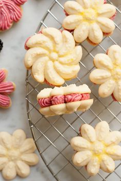 some cookies that are sitting on a wire rack with flowers in the middle and one cookie has been cut into smaller ones