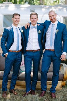 three men in blue suits posing for the camera