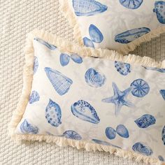 two blue and white pillows with shells on them