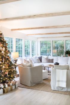 a living room filled with furniture and a christmas tree