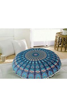 a blue and white round floor pillow sitting on top of a bed