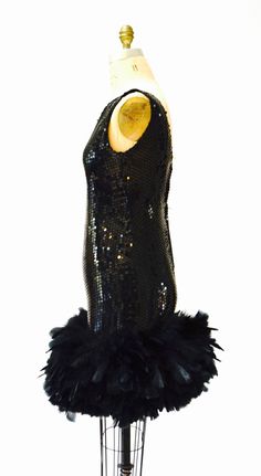 "Breathtaking party dress Black sequins with feathers This lovely features: * Black bodice fully embellished with black sequins * gorgeous super full Feather trim around the hemline * Back zip closure and fully lined * Stunning Dana Deatherage Size Small Synthetic lining Excellent vintage condition Bust 34\" Waist 31\" Hip 37\" Front body length from top of bodice 36\" Visit the shop https://www.etsy.com/shop/Hookedonhoney ** twitter | hookedonhoney ** pinterest | hookedonhoney ** Instagram | ho Black Flapper Sequin Party Dress, Black Flapper Sequin Dress For Party, Glamorous Black Sequined Flapper Dress, Black Cocktail Dresses With Ostrich Feathers, Black Ostrich Feather Cocktail Dress, Fitted Gatsby Sequin Party Dress, Glamorous Evening Flapper Dress With Feathers, Black Ostrich Feather Dress For Night Out, Glamorous Feathered Flapper Dress For Cocktails