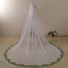 a wedding veil with green leaves on the bottom