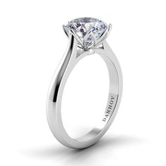 a white gold engagement ring with a round brilliant cut diamond in the center, on a plain