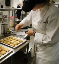 a person in a kitchen preparing food on trays