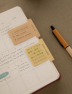 an open notebook with stickers on it next to a pen