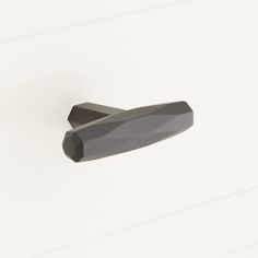 a black door handle on a white wall