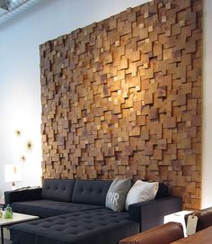 a living room filled with furniture and a large wooden wall behind the sectional couches