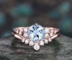 an engagement ring with a blue topazte surrounded by white diamonds on a rock