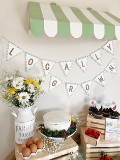 a table topped with cakes and cupcakes on top of wooden crates next to a sign that says local grown