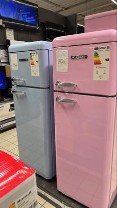 two pink refrigerators sitting side by side in a store