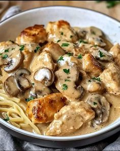 a white bowl filled with pasta covered in mushroom gravy and mushrooms on top