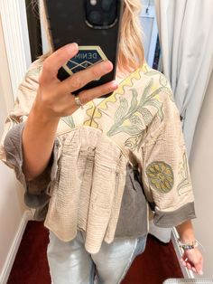 Get ready to boho in this Dusty Olive Embroidered Top! Its vintage embroidery patch adds a unique touch to this fun and relaxed A-line top. Made of woven gauze, it features a V-neck line and solid contrast on the sleeve ends and sides. Perfect for a playful and carefree look! Summer Linen Patchwork Tops, Spring Folk Style V-neck Peasant Top, Long Sleeve Patchwork Top For Vacation, Cotton Patchwork V-neck Blouse, Cotton V-neck Patchwork Blouse, Spring V-neck Patchwork Blouse, V-neck Cotton Blouse With Patchwork, V-neck Top With Geometric Embroidery For Fall, Bohemian V-neck Blouse With Embroidered Hem