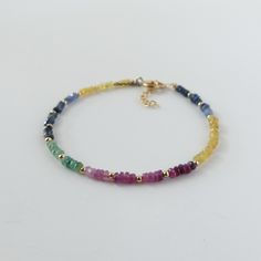 Introducing this stunning rainbow Ruby, Emerald, Blue and Yellow Sapphire mixed bracelet, featuring dainty, skinny minimalist design.  This  2.5mm gemstone beaded bracelet will make an ideal gift for women. Ruby is July Birthstone, Emerald is May Birthstone and Sapphire is September Birthstone, making it an ideal  jewelry gift for a mother, friend, girlfriend, daughter, sister, teacher, wife, bride, bridesmaid, or yourself. It is perfect for stacking or layering all year around. It is timeless and classy and made to last. It will come in a gift-ready pouch. Perfect engagement, wedding, birthday, or anniversary gift. -2.5mm mix of different shades of Emerald, Ruby, and Sapphires (Yellow and blue). Note that the bracelet appears larger in photos due to its close-up view -Choice of sterling s Rainbow Adjustable Minimalist Jewelry, Minimalist Adjustable Rainbow Jewelry, Rainbow Dainty Jewelry With Round Beads, Elegant Rainbow Bracelets With Round Beads, Dainty Rainbow Round Beaded Jewelry, Dainty Rainbow Round Bead Jewelry, Rainbow Round Beads Dainty Jewelry, Elegant Rainbow Round Beads Bracelet, Dainty Rainbow Beaded Jewelry