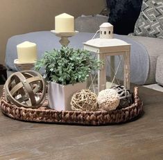 a tray with candles and decorations on top of a wooden table in a living room