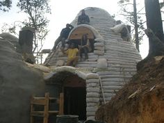 people are sitting on top of a building made out of sandbags