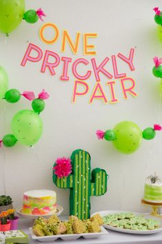 a table topped with cakes and desserts next to a sign that says one prickly parr