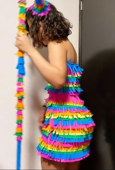 a woman in a colorful dress is holding a pole