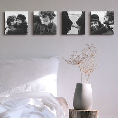 three black and white photos hang on the wall above a bed with pillows, vases and flowers