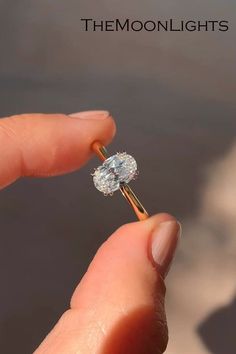 a person holding a diamond ring in their hand