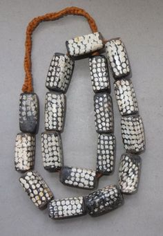 an old beaded necklace with white and black beads