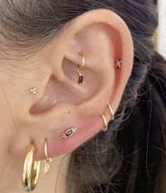 a close up of a person's ear with three different types of piercings