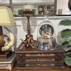 an antique clock and other items sit on a table in front of a mirror with a lamp next to it