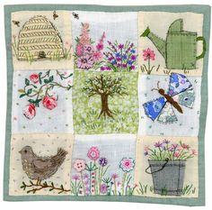 a patchwork quilt with flowers, birds and watering can on the front is shown