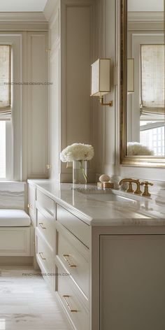 a white bathroom with marble counter tops and drawers