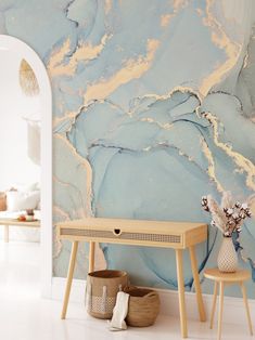 a table and two stools in front of a wall with blue paint on it