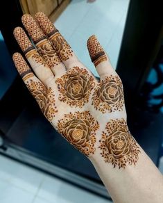 a person's hand with henna on it and flowers painted on the palm