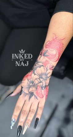 a woman's hand with flowers on it and nails in the middle of her arm