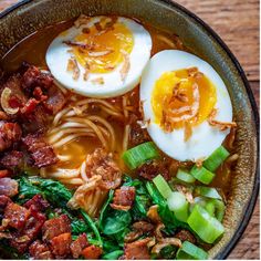 a bowl filled with noodles, meat and hard boiled eggs on top of it's sides