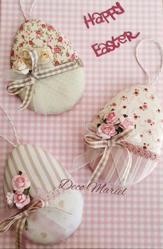 three decorative easter eggs on a pink and white checkered tablecloth