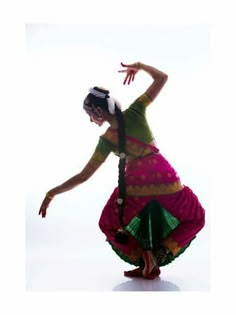 a woman in a colorful dress is dancing